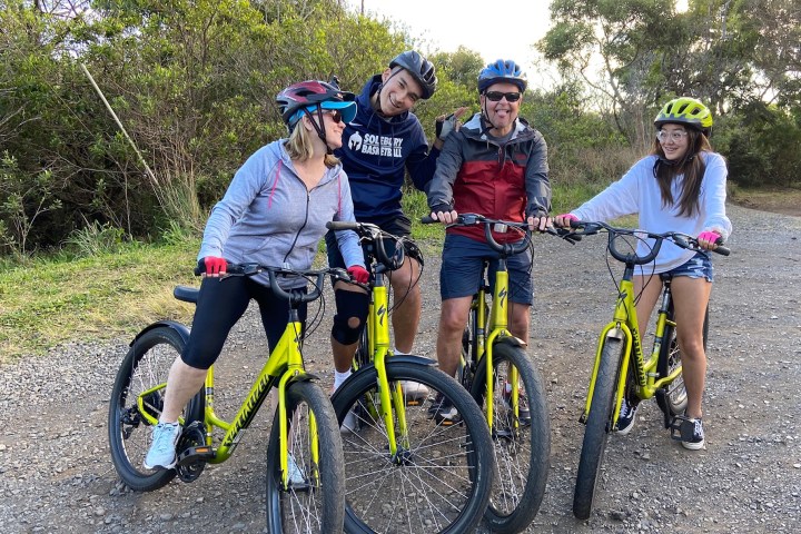 a group of people riding on the back of a bicycle