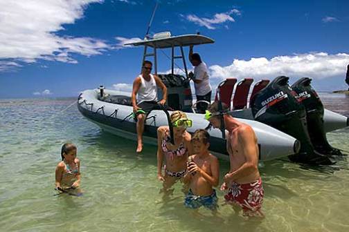 a group of people standing next to a body of water