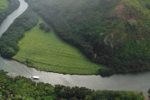 a boat traveling down the wailua river.