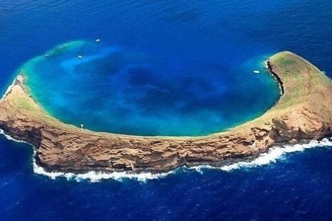 a body of water with Molokini in the background