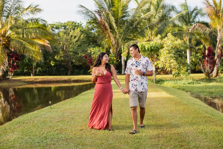 a young girl standing next to a palm tree