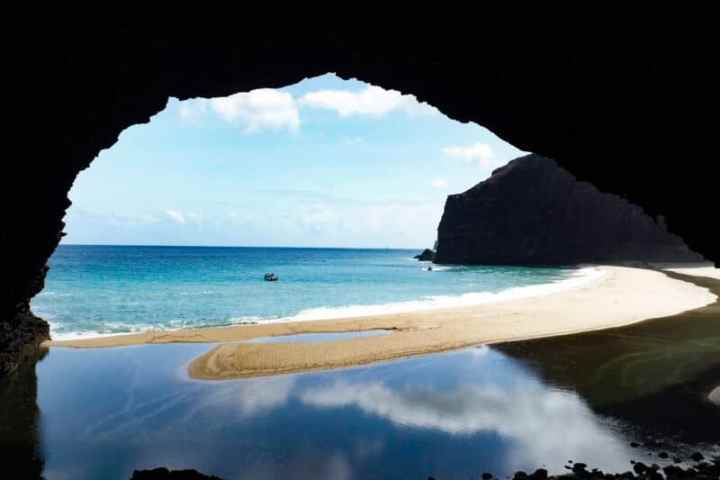 a body of water with a mountain in the ocean