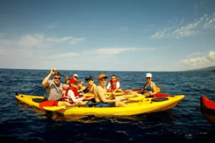 a group of people in a small boat in a body of water