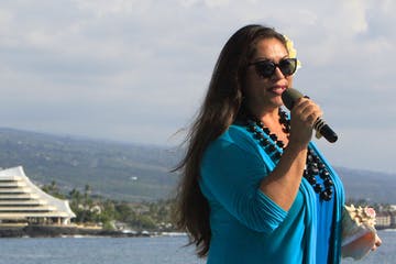 a woman standing in front of a body of water
