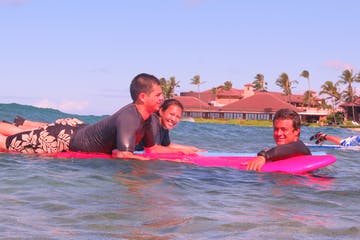 a young man riding a surfboard in the water