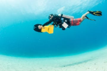 a person flying through the air while swimming in blue water
