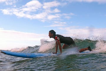 a girl riding a wave on a surfboard in the water