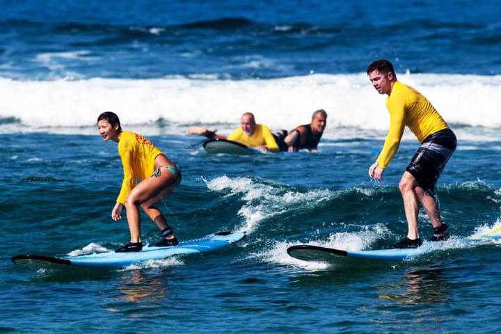a young girl riding a wave on a surfboard in the ocean
