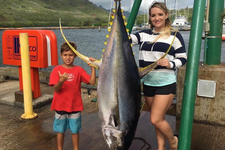 a young boy holding a fish