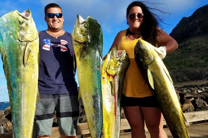 a group of people standing next to a person holding a fish