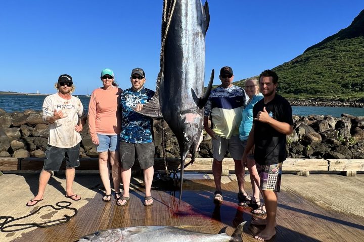 a group of people standing in front of a fish