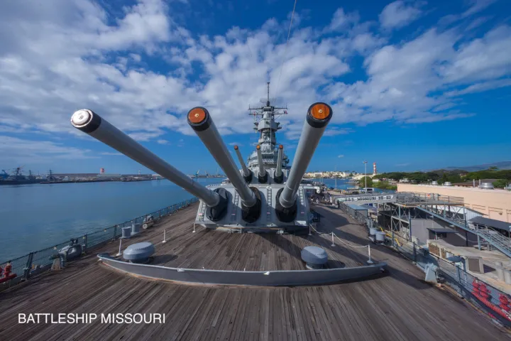 a large ship in the background with USS Missouri (BB-63) in the background