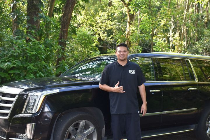 a man standing in front of a car posing for the camera