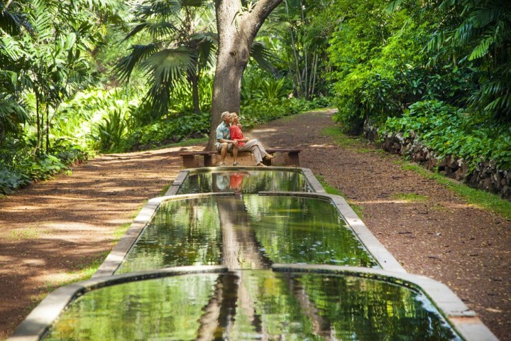 a person sitting on a bench next to a river