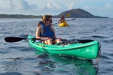 a person in a green boat on a body of water