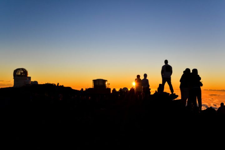 a person standing in front of a sunset