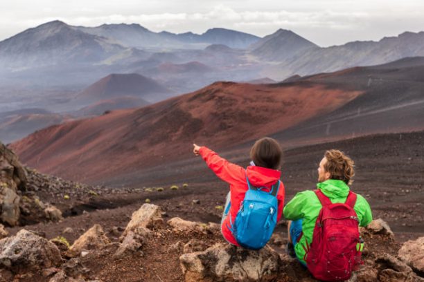 a boy standing in front of a mountain