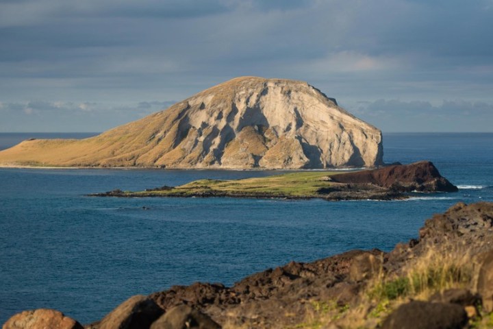 a rocky island in the middle of a body of water