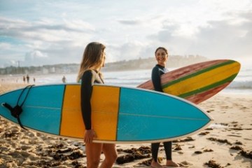 a person carrying a surf board on a beach