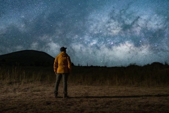 a man standing on top of a grass covered field