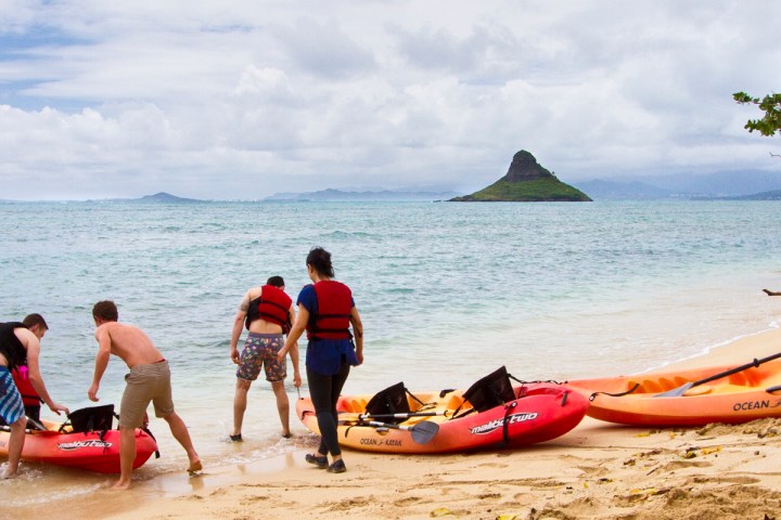 a group of people in a boat on the beach