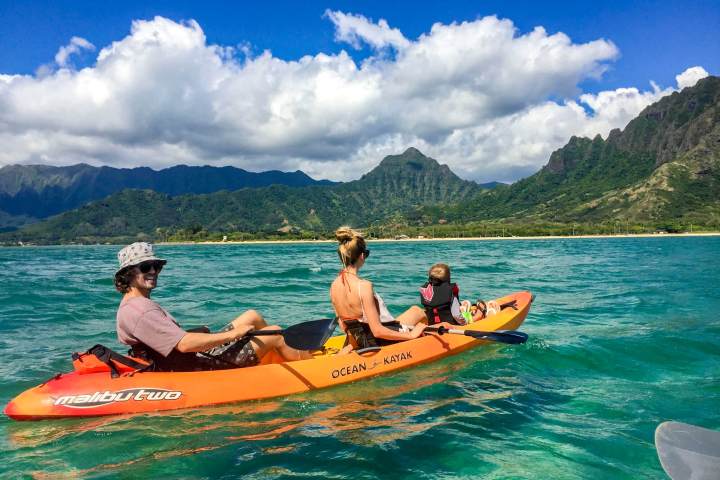 a group of people riding on the back of a boat in the water