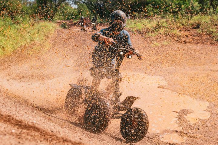 a man riding a atvdown a dirt road
