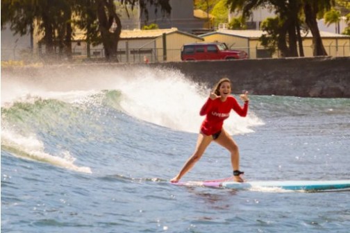 a girl riding a wave on a surfboard in the water