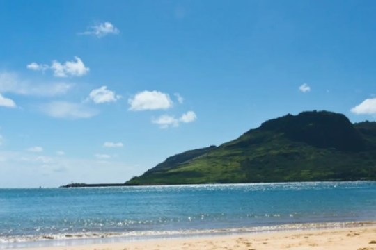 an island in the middle of a sandy beach next to the ocean