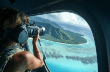 Air maui Person photographing a tropical island from an airplane window