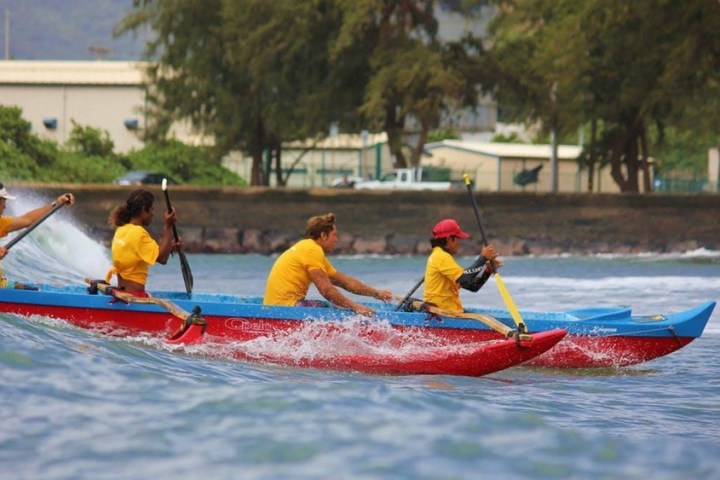 a group of people riding on the back of a boat in the water