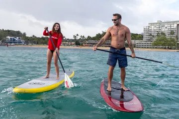 a man standing next to a body of water