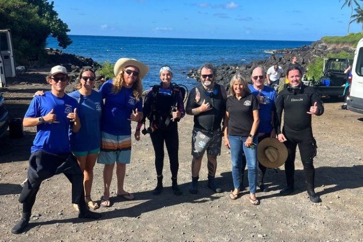 a group of people on a beach posing for the camera