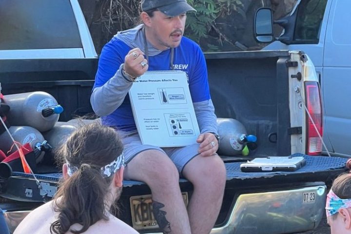 a group of people sitting around a car