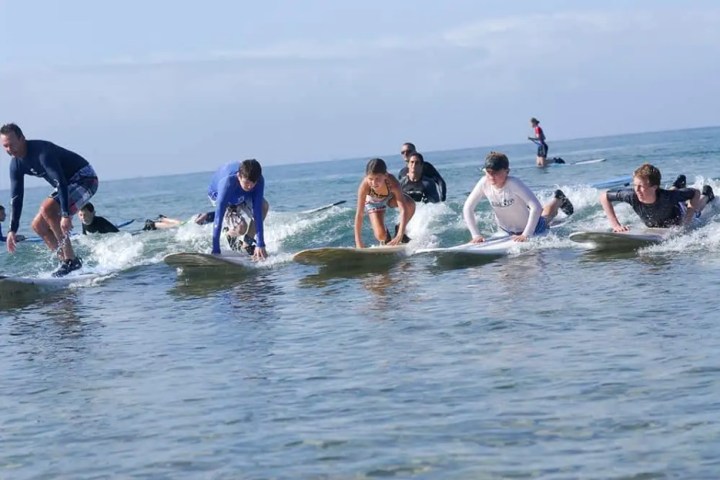 a group of people riding on top of a body of water