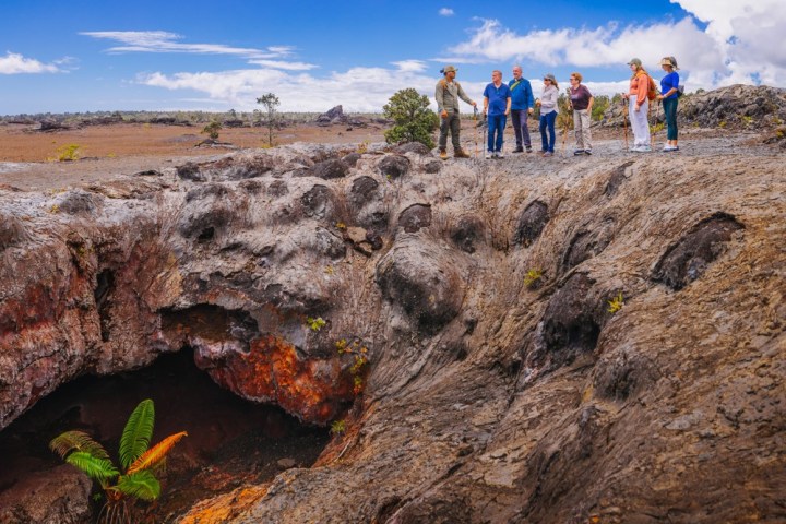 a group of people standing on lava rock