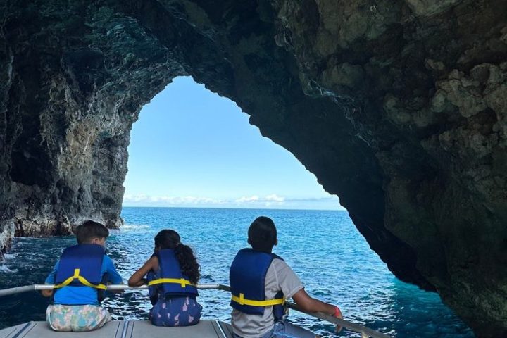 a group of people on a boat in a sea cave