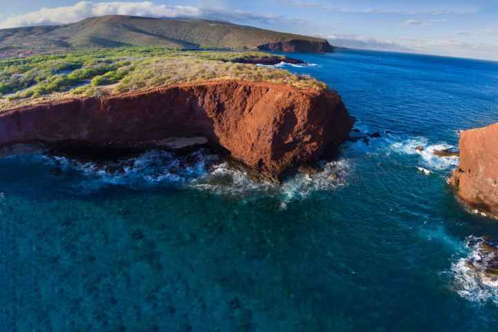 a body of water with a mountain in the ocean