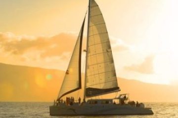 Silhouetted sailboat with people at sunset on calm water.