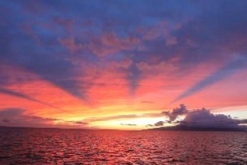 Vibrant sunset over ocean with colorful sky and clouds